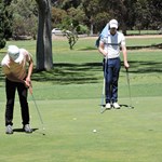 Chantha putts while Corey looks on